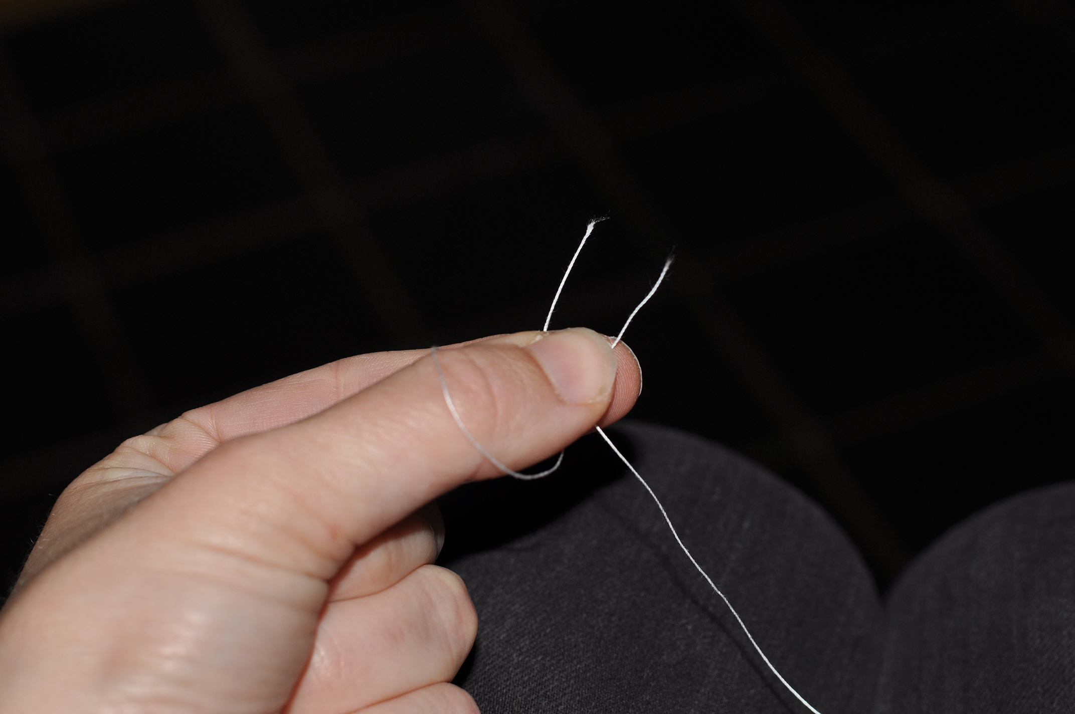 Put the right-hand thread over the thumb and behind the one on the left. Then put it in front of the right one. 