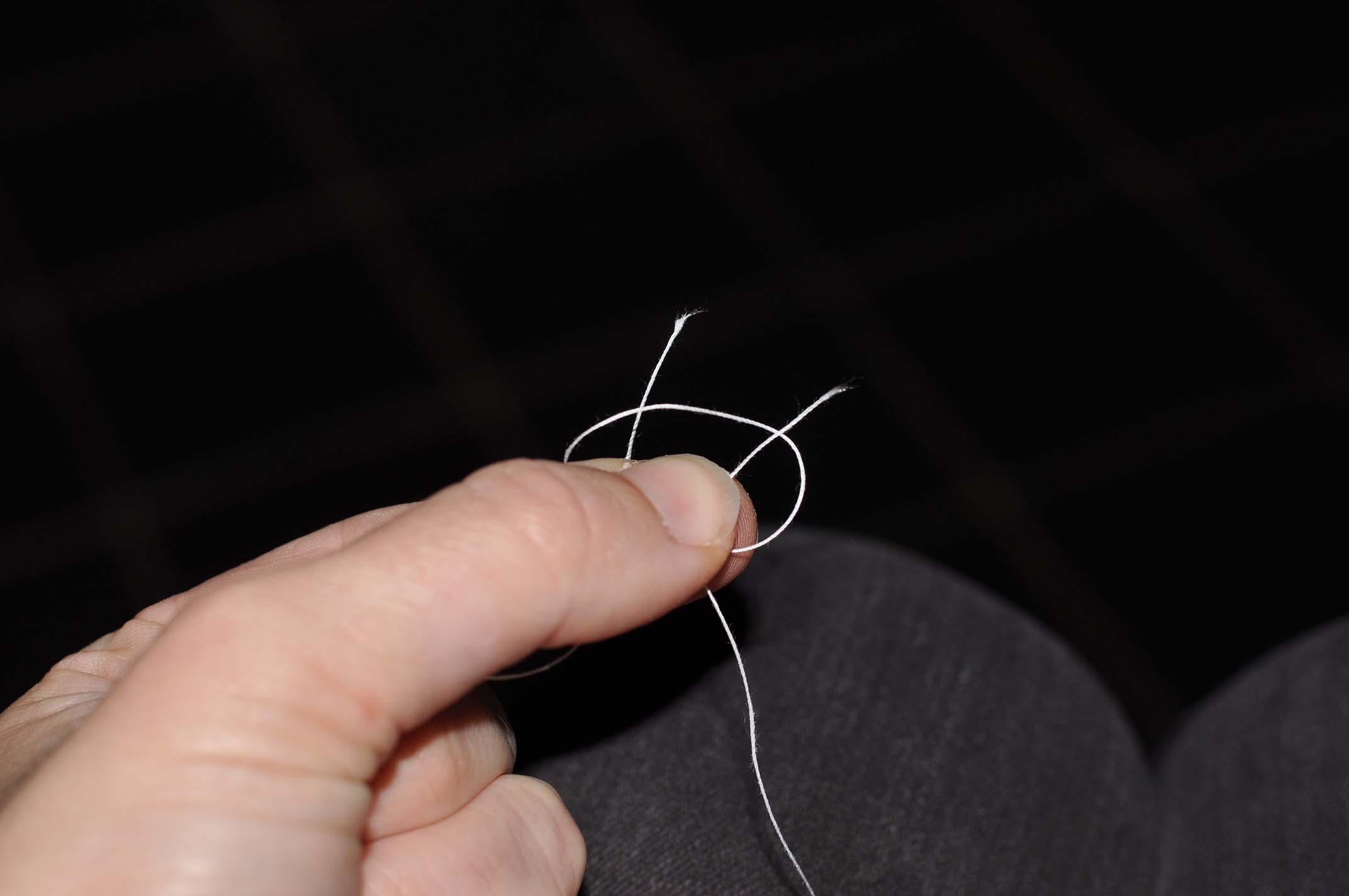 Remove the loop on the thumb and pull the thread on the right side through it. 