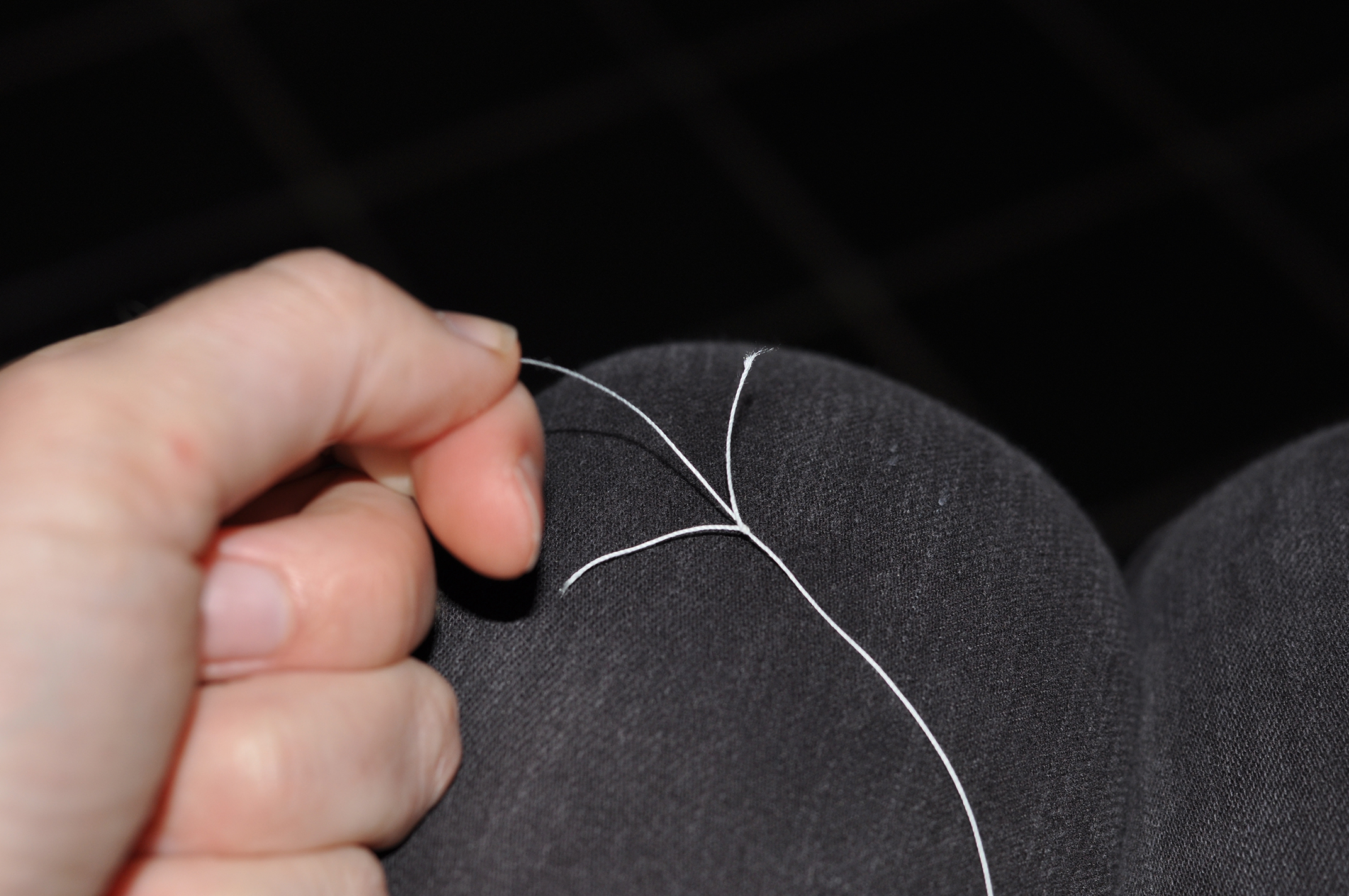 While squeezing the thumb and forefinger, pull the bobbin on the right to make a loop. Then pull both bobbins apart to tighten the knot. 